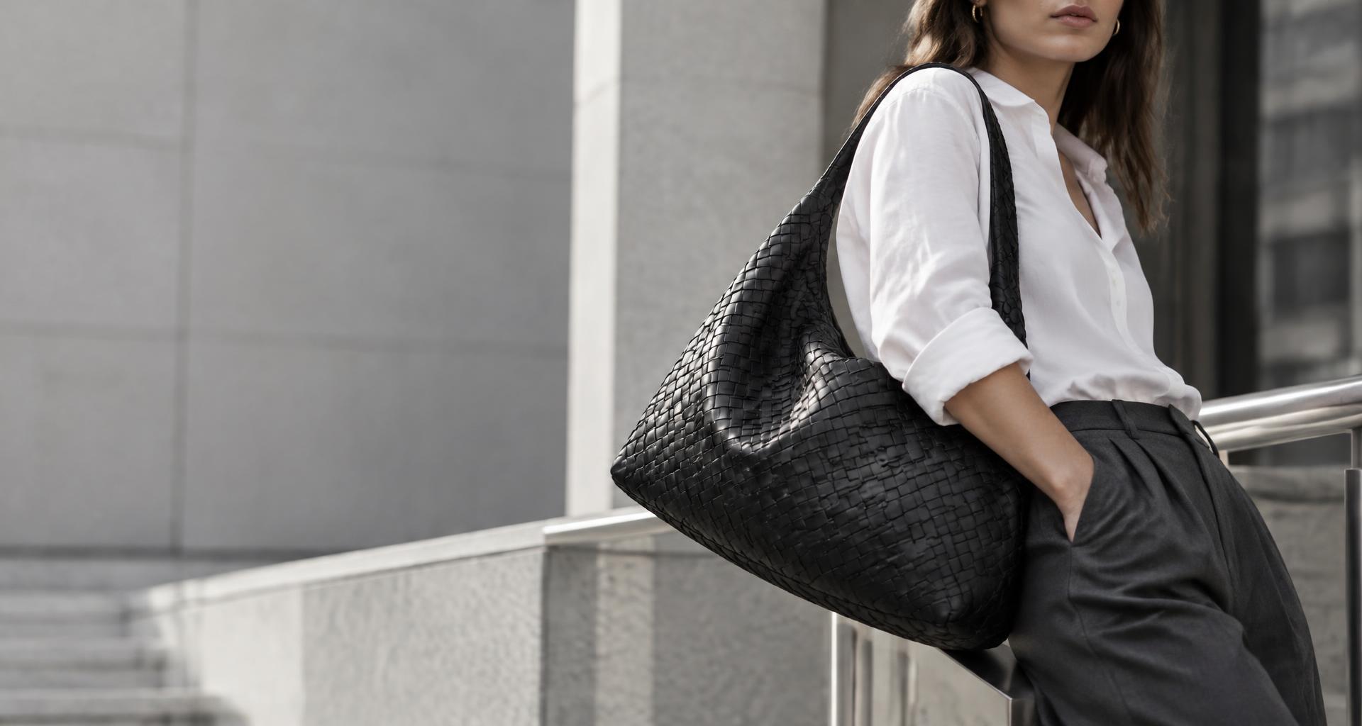 Editorial campagne met een geweven zwarte leren tas en witte blouse